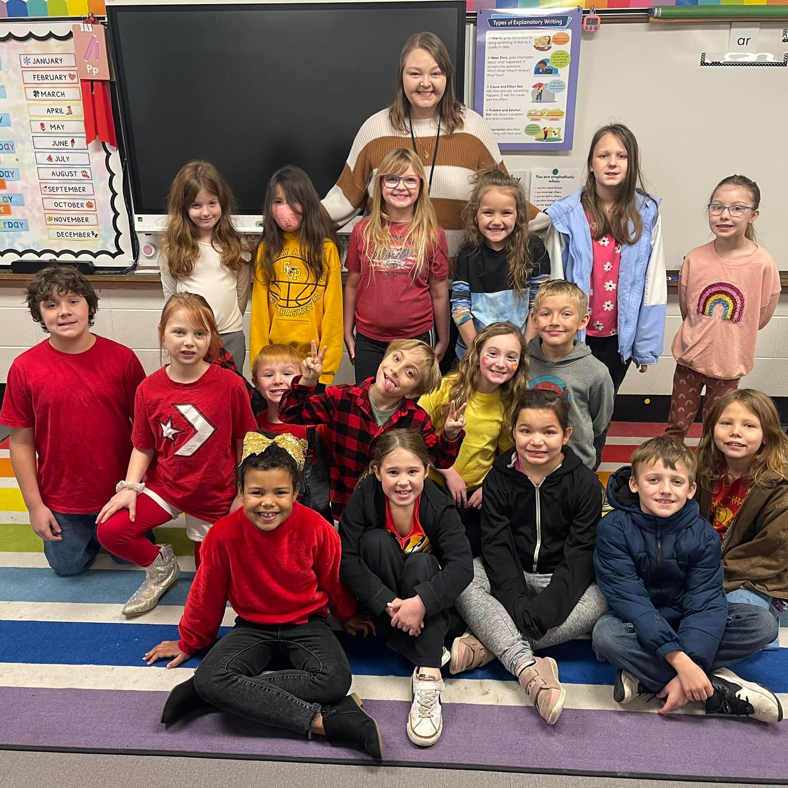 teacher smiles with students in classroom