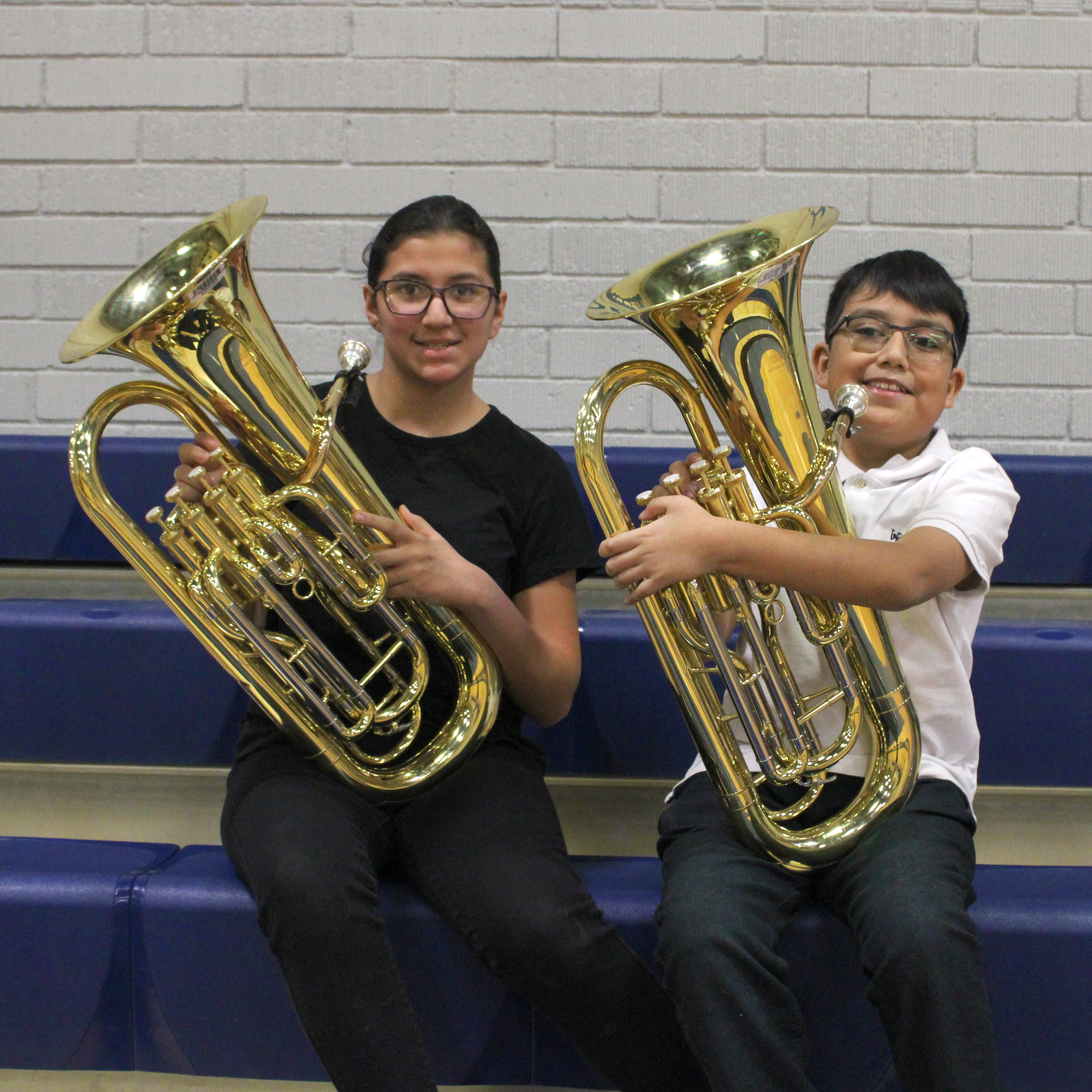 two band students posing for photo with their instruments 