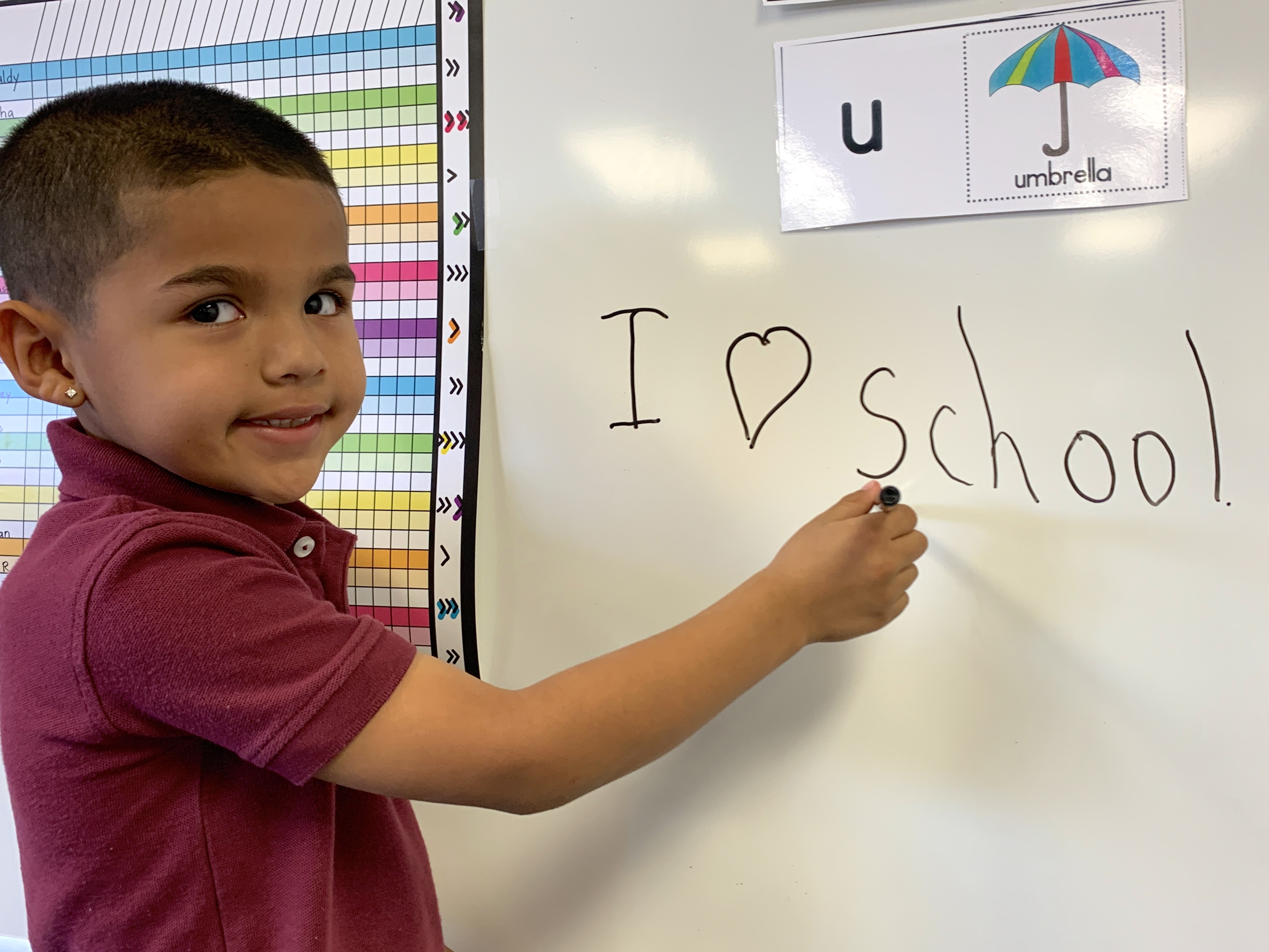 Student in front of white board that says I love school