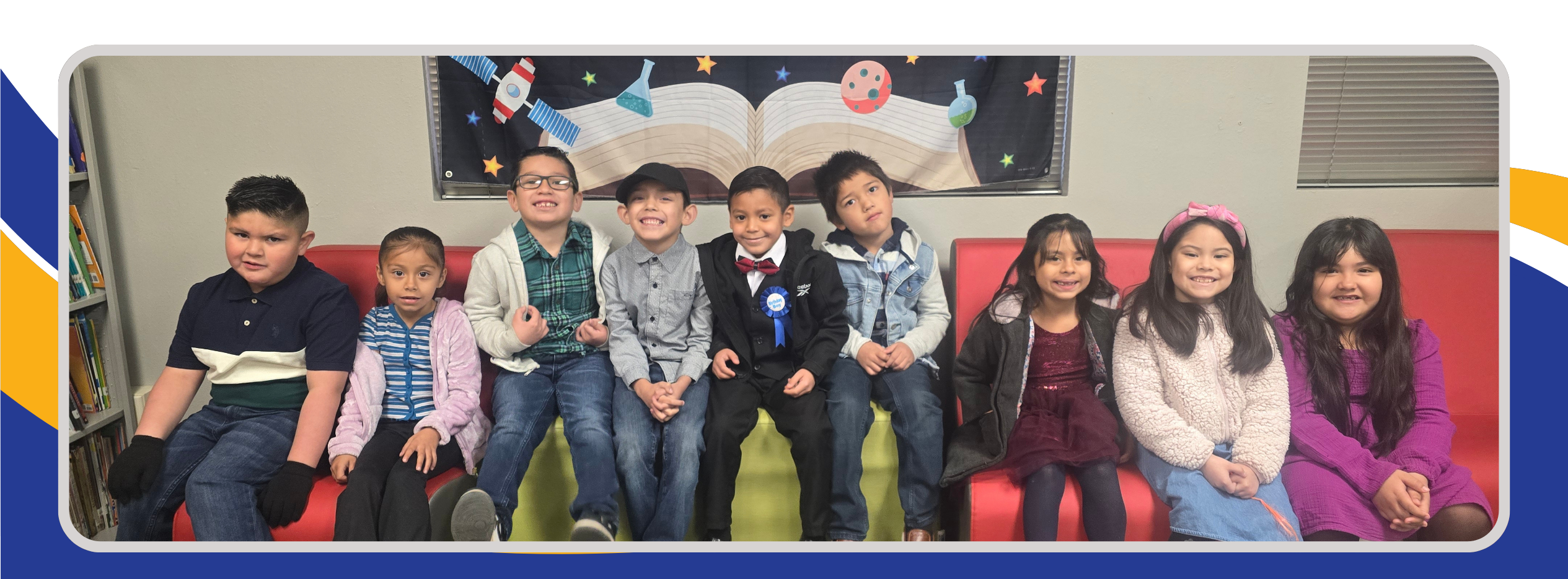 Students sitting together, dressed in Spirit Week attire, showcasing various themed outfits. The group appears cheerful and engaged, reflecting the celebratory and fun atmosphere of Spirit Week.