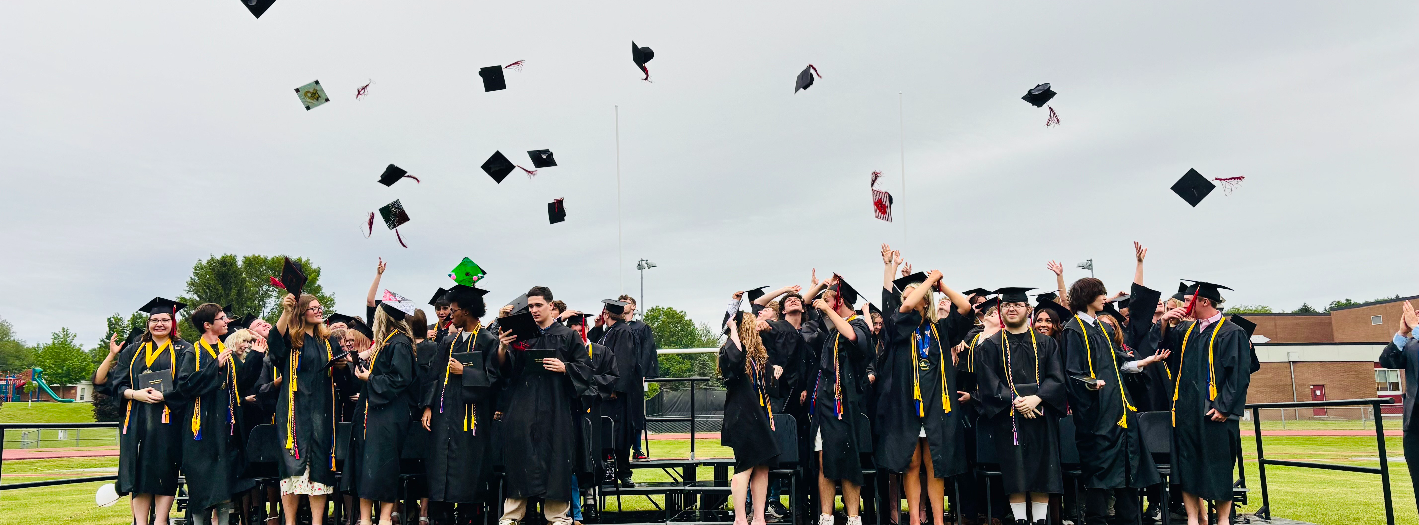 graduates throwing caps in air