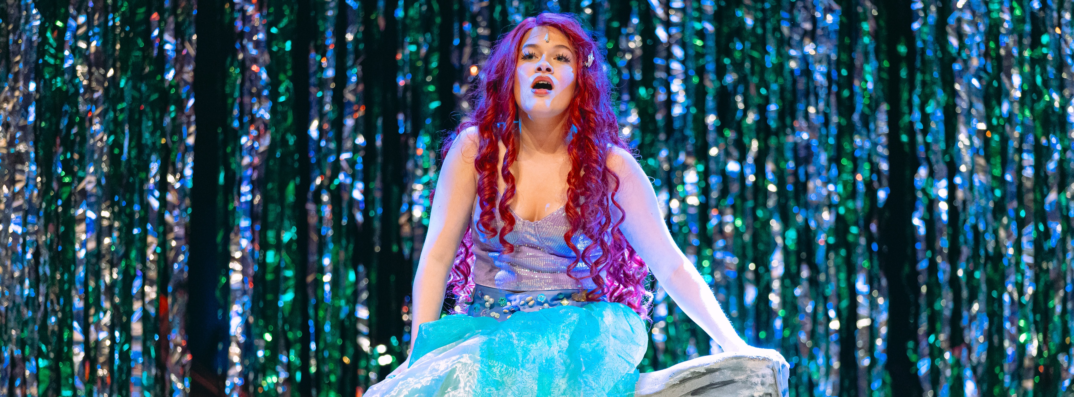 girls playing Ariel the mermaid on stage