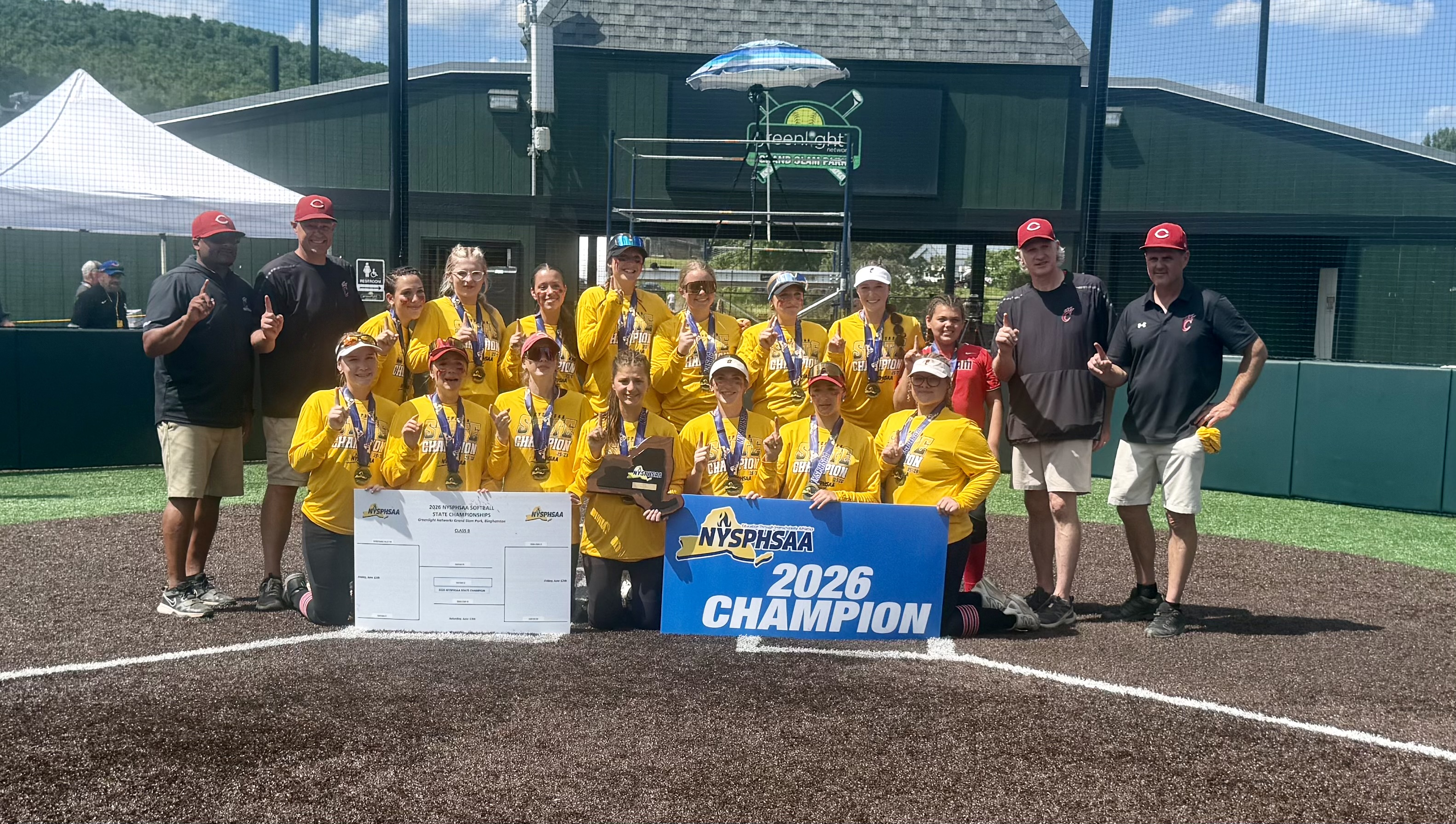 varsity softball team with NYS 2026 champion banner