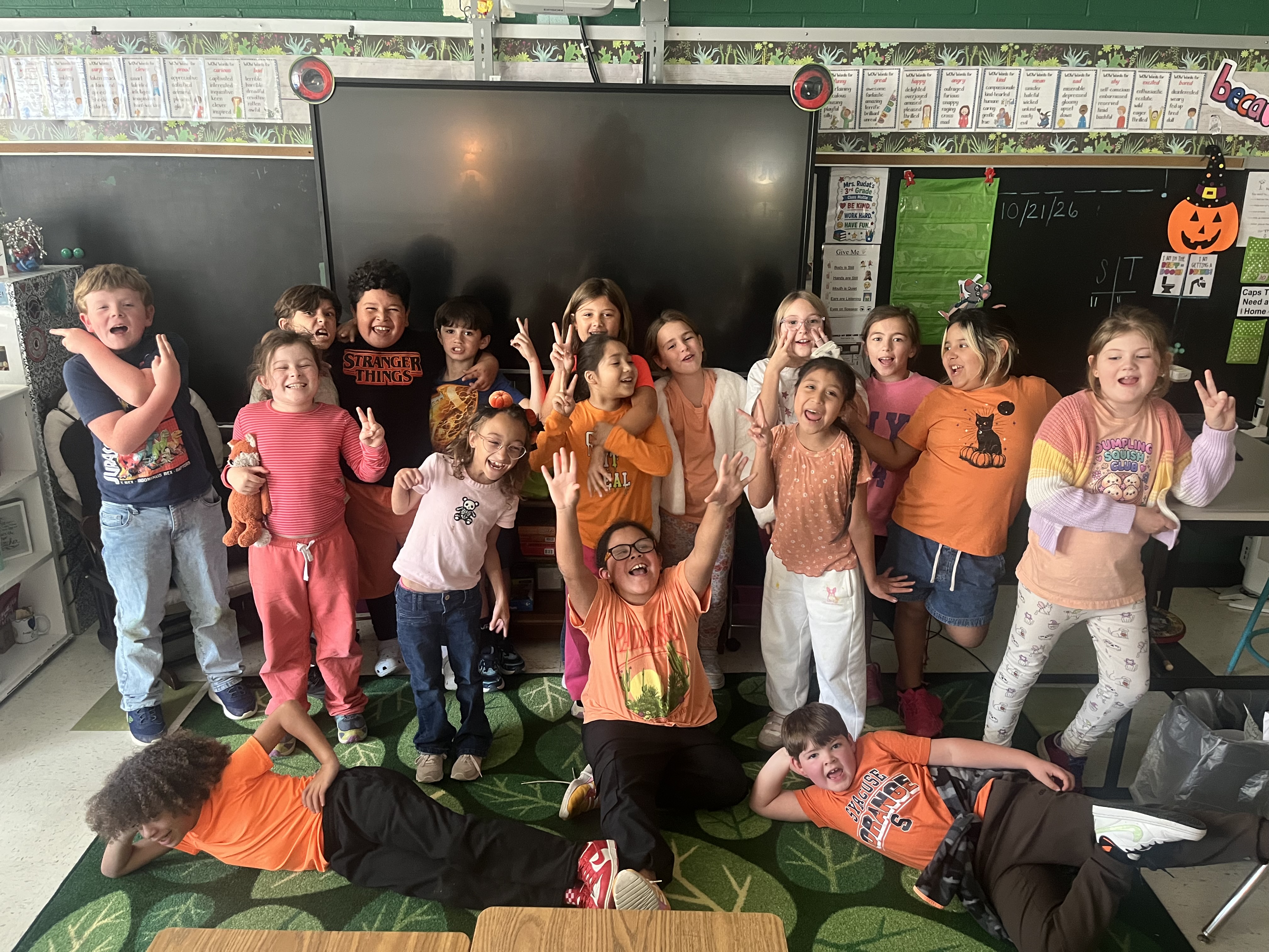 Elementary School students pose for silly group photo of them wearing orange