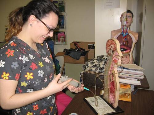 Photos of the Nursing Assisting 2016 Program, a student learning anatomy