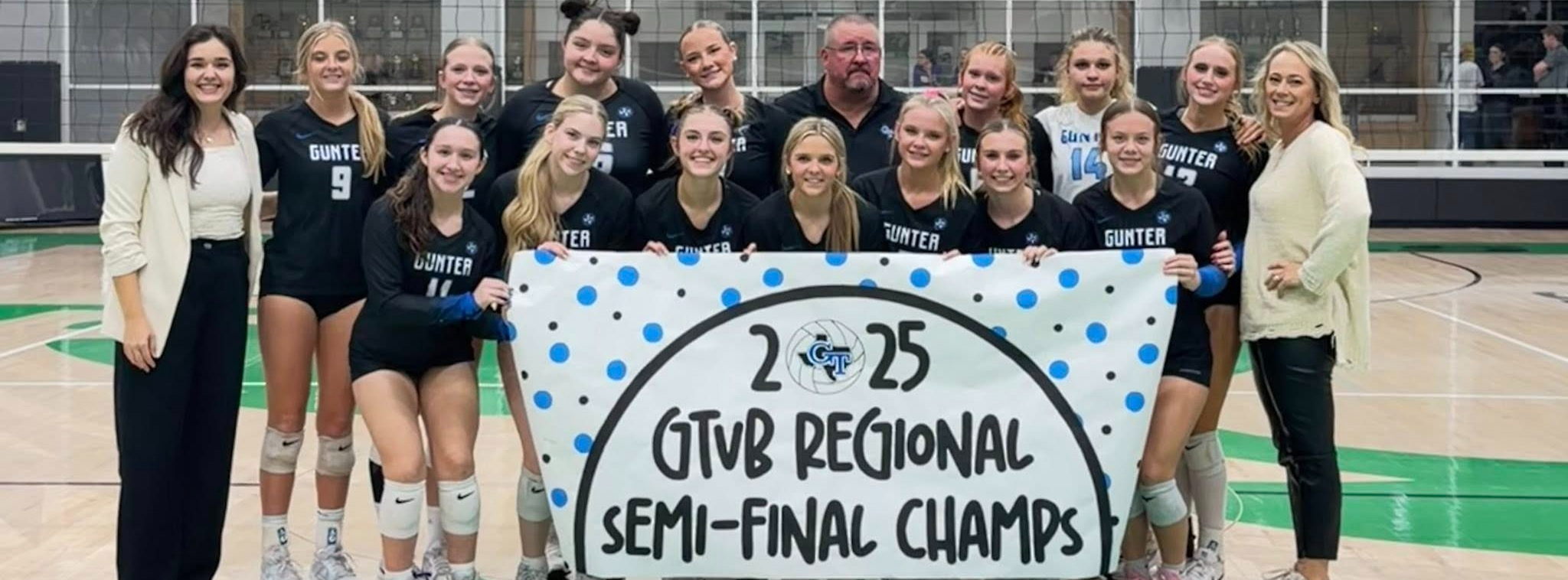 A group of volleyball players in front of a sign that reads 2025 Regional Semi-Final Champs.