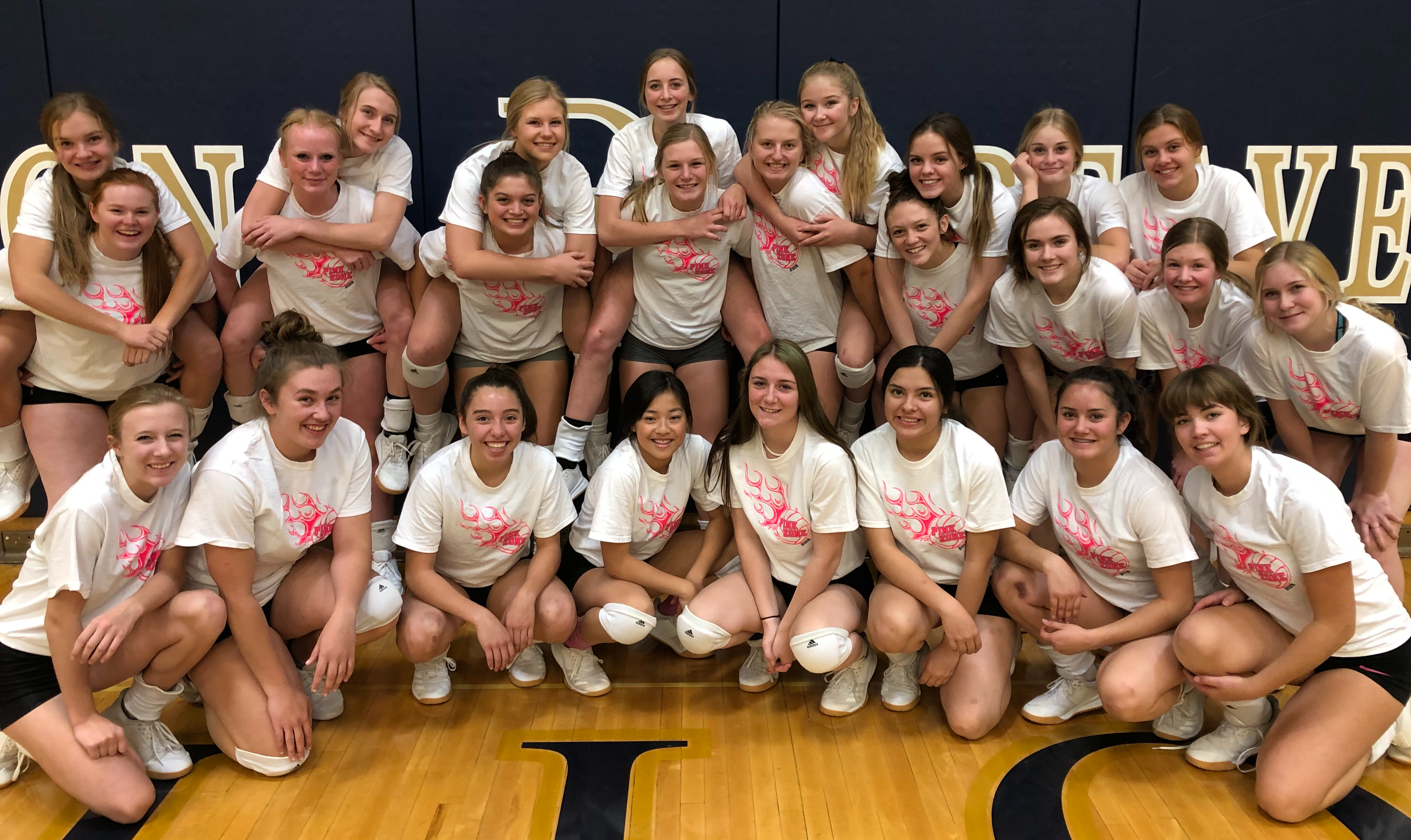 A photo of the volleyball team celebrating their Dig Pink match against Butte Central in October 2019