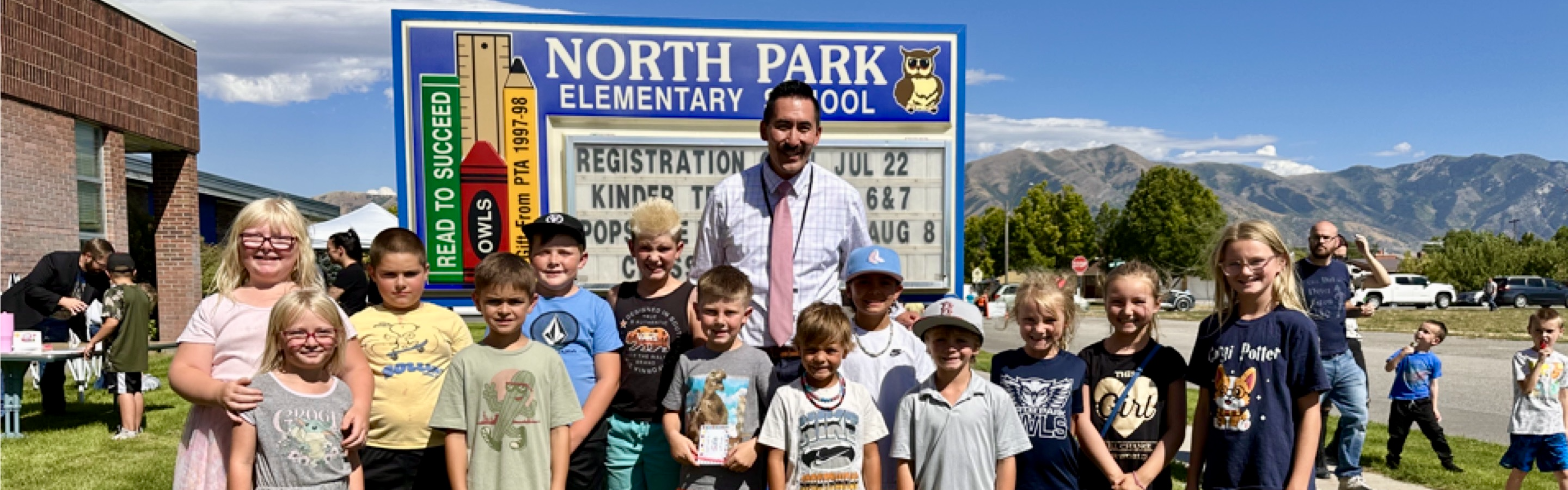 Back to School Night event. There are students and Principal Greene standing in front of the North Park sign.