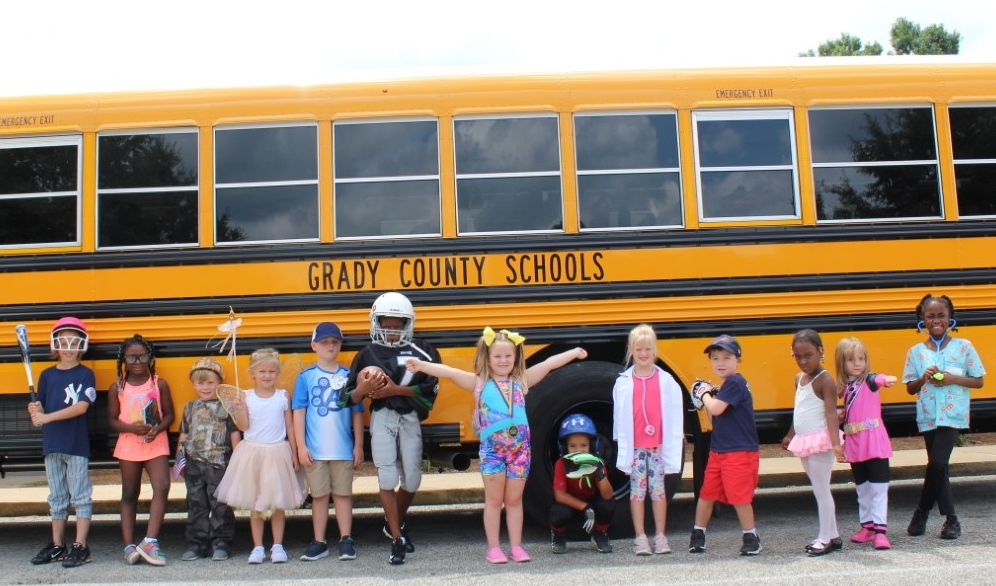 GCS students in costume in front of a bus