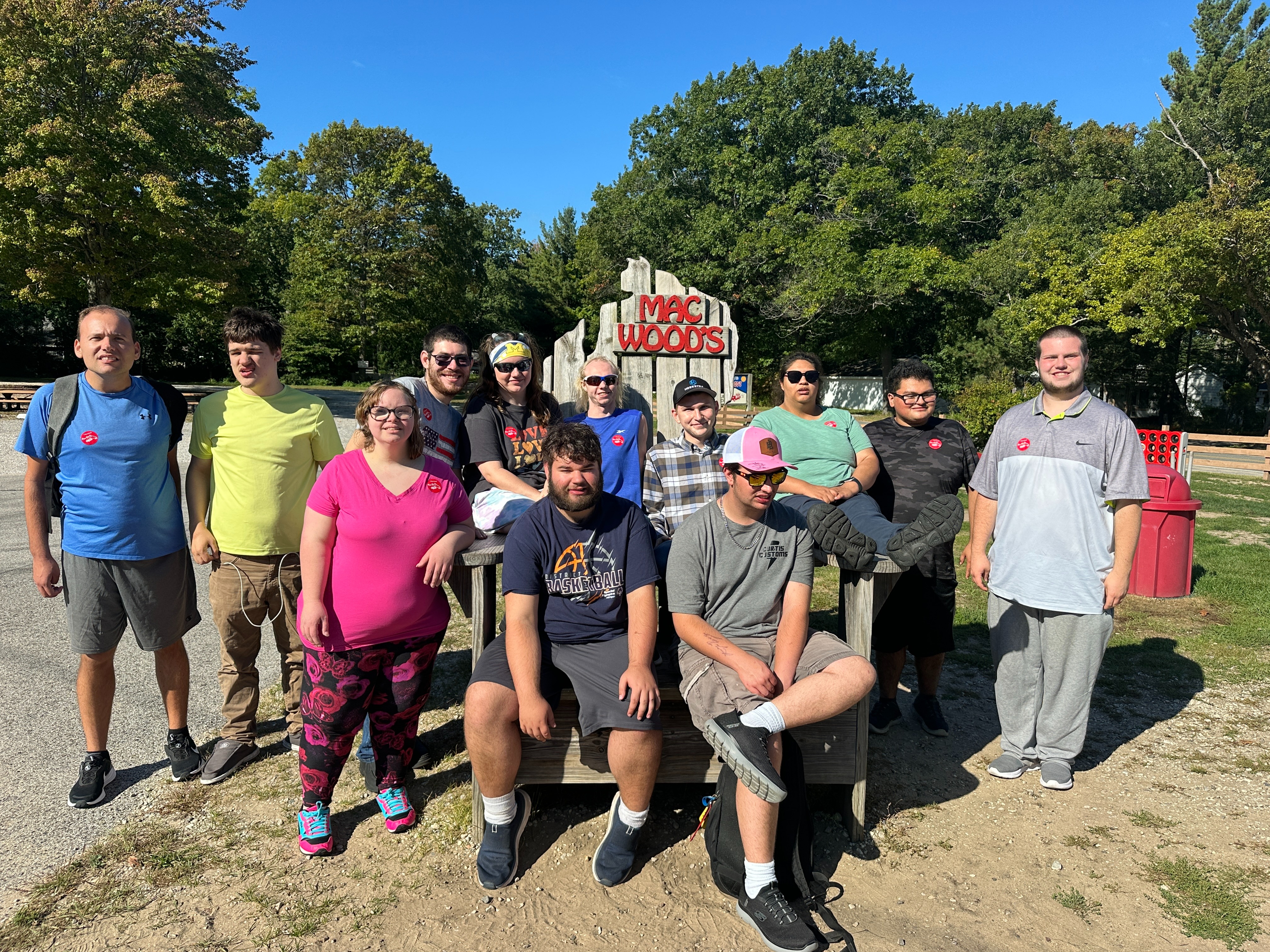Group of staff and students standing outside mac woods sign
