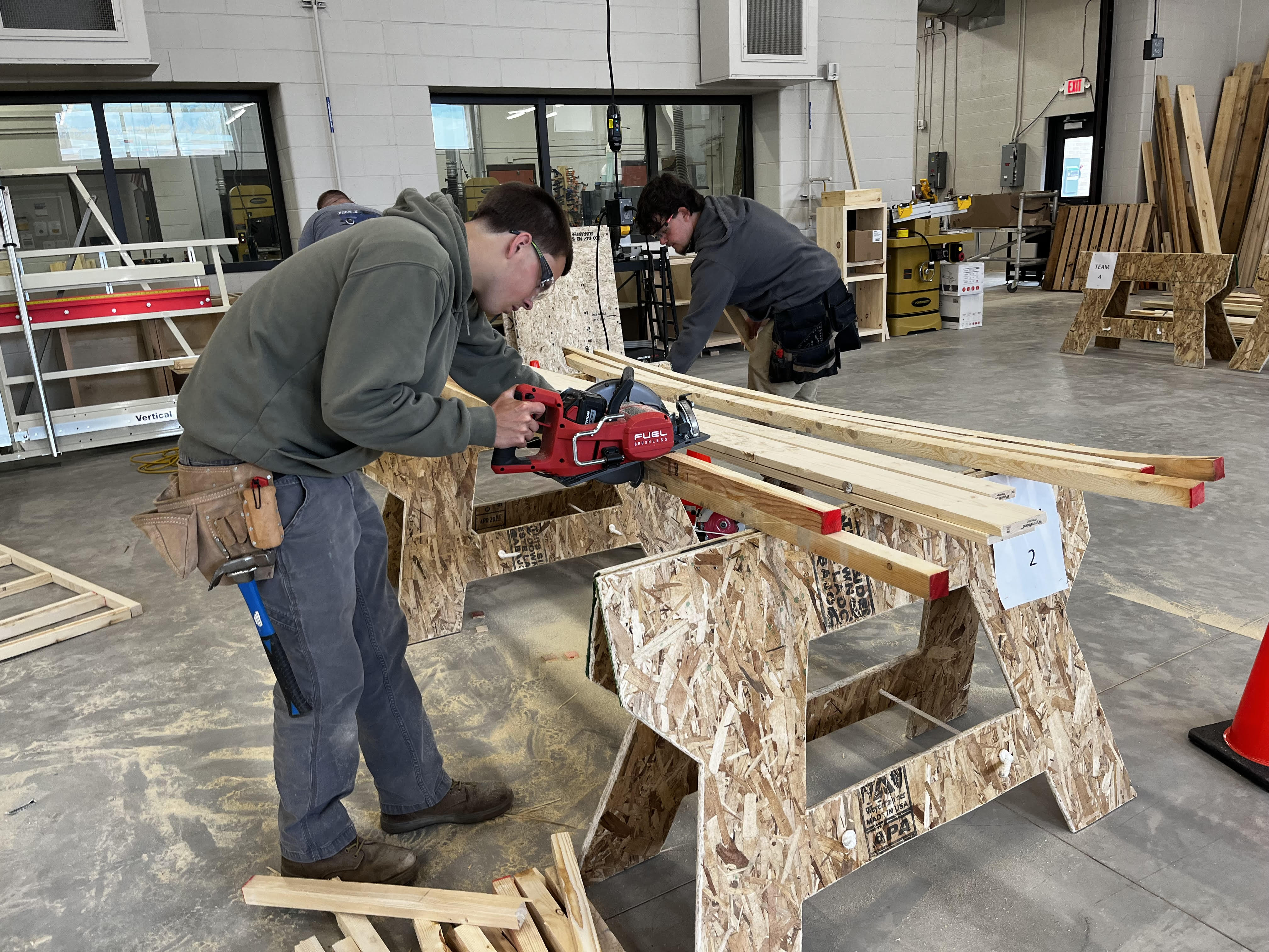 Student cutting a board with a saw