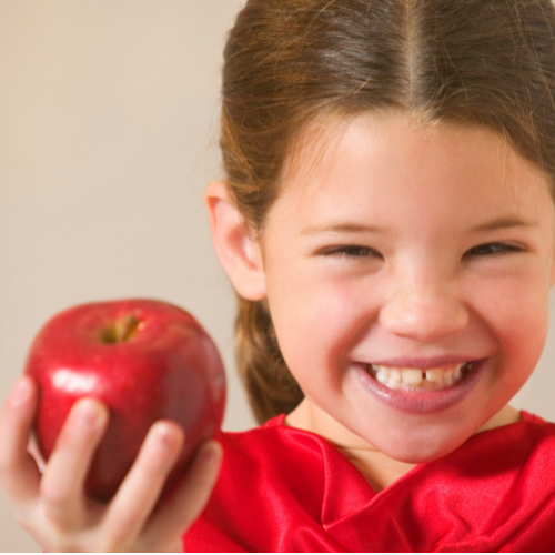 Smiling girl holding red apple