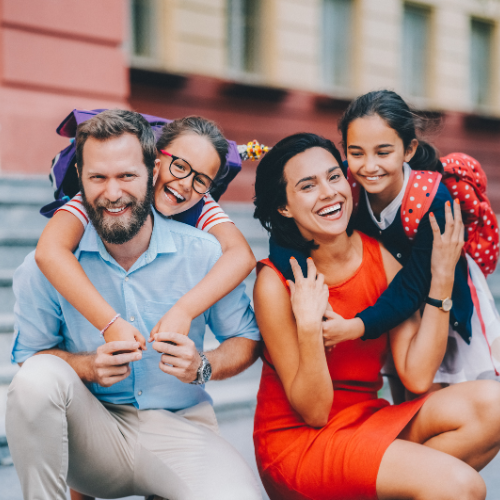 two adults and a smiling children  - both wearing backpacks 