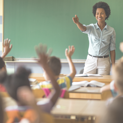 Students raising their hands and a teacher pointing to a student