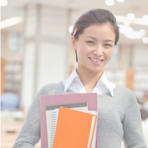 A teacher holding some paper items