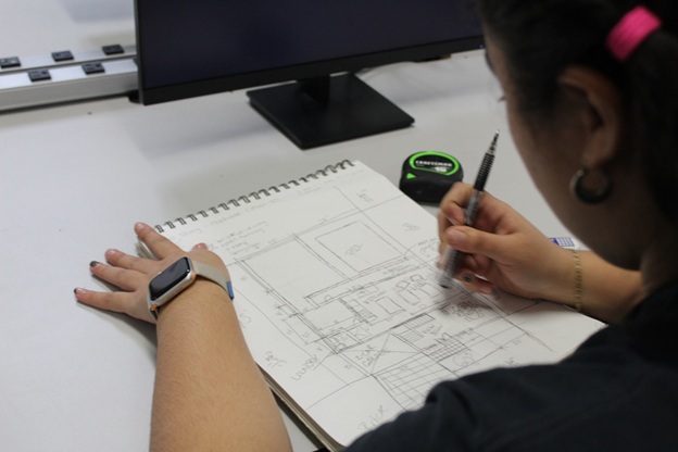 Student sketching floor plan