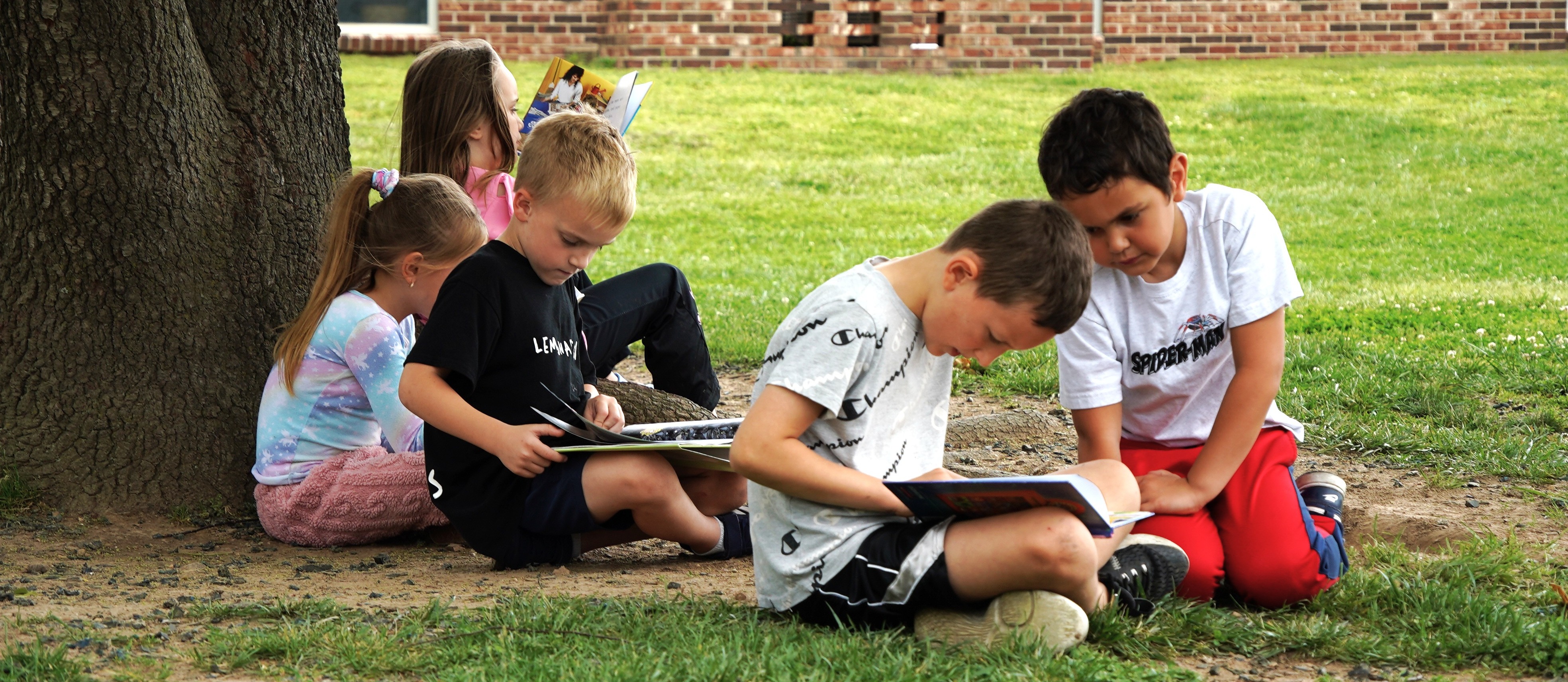 Children reading under a tree on Earth Day