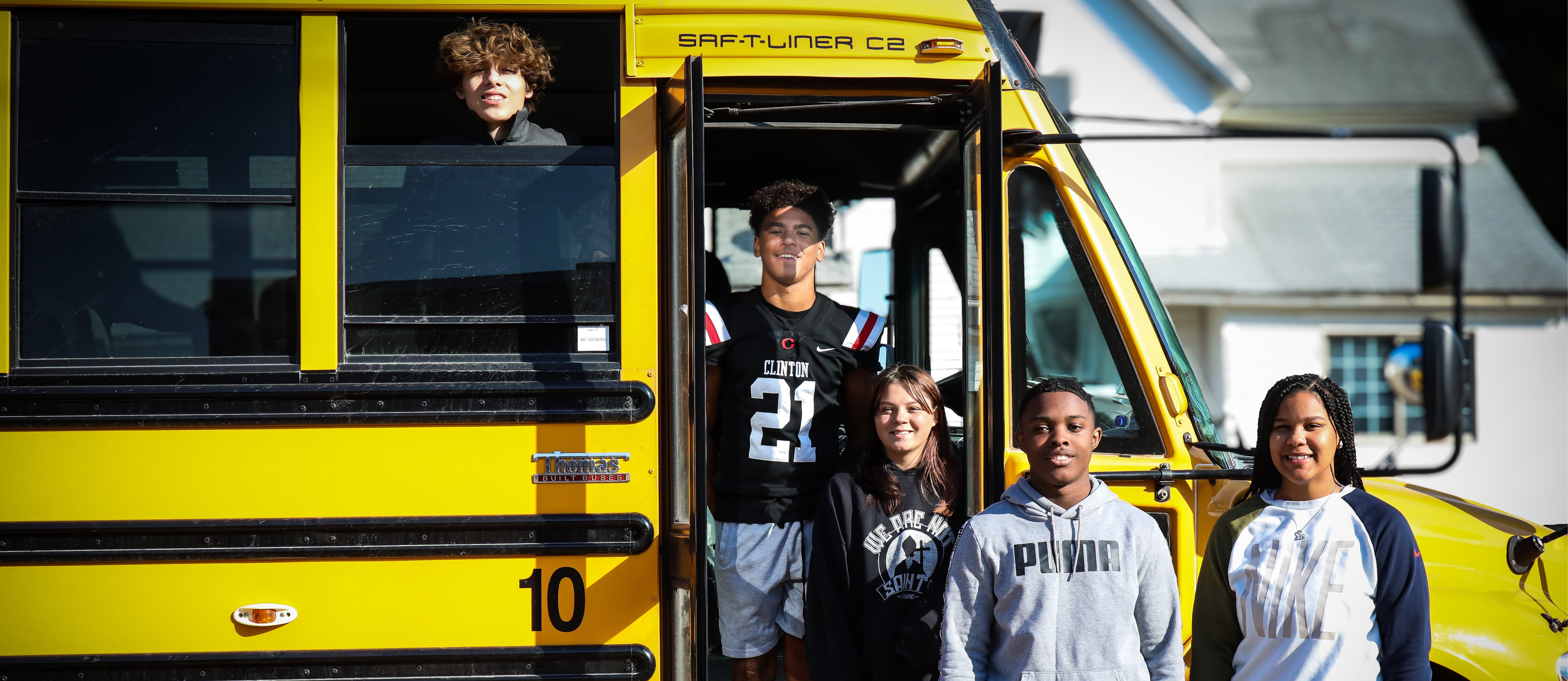 Students posing outside bus