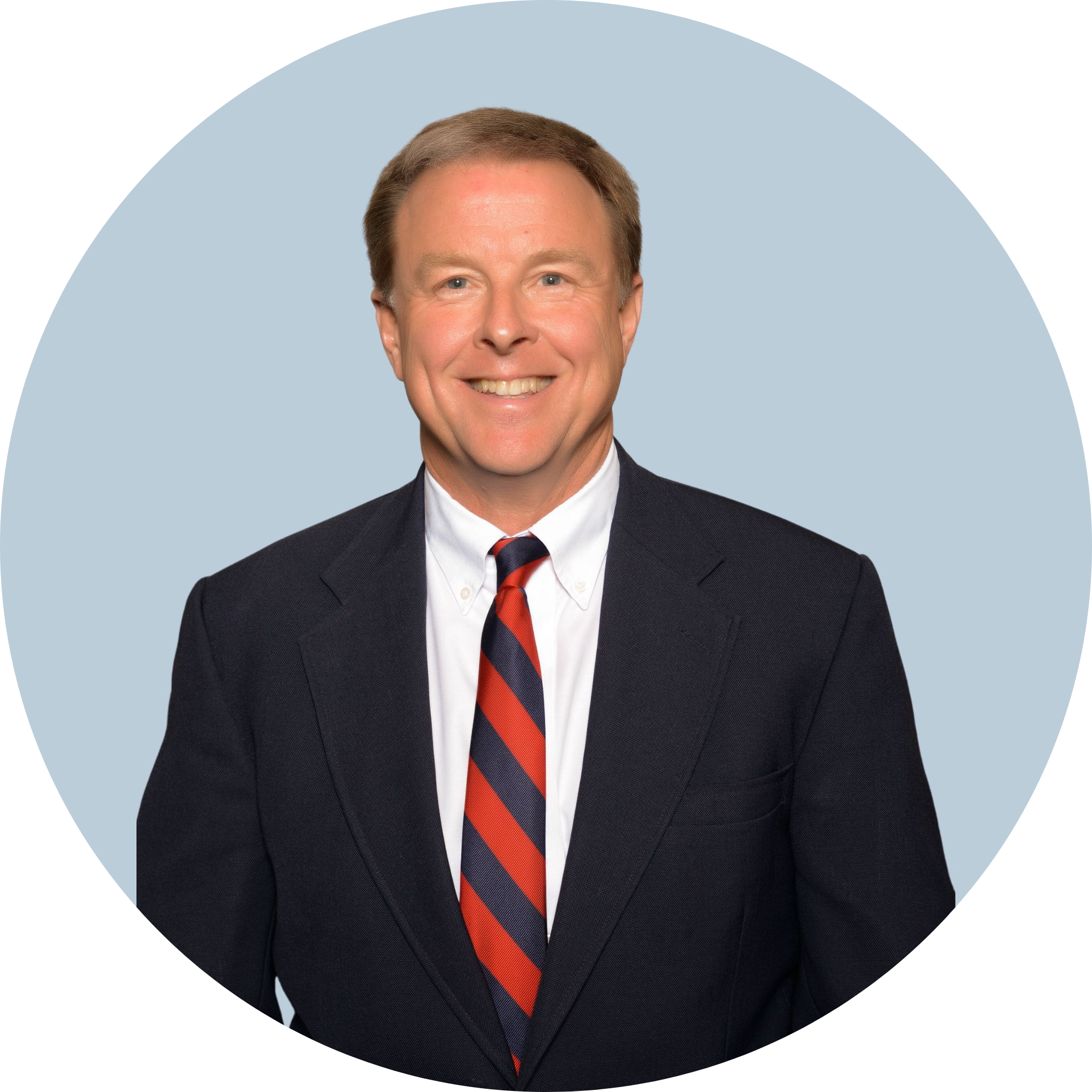 A smiling man is wearing a jacket and a striped tie