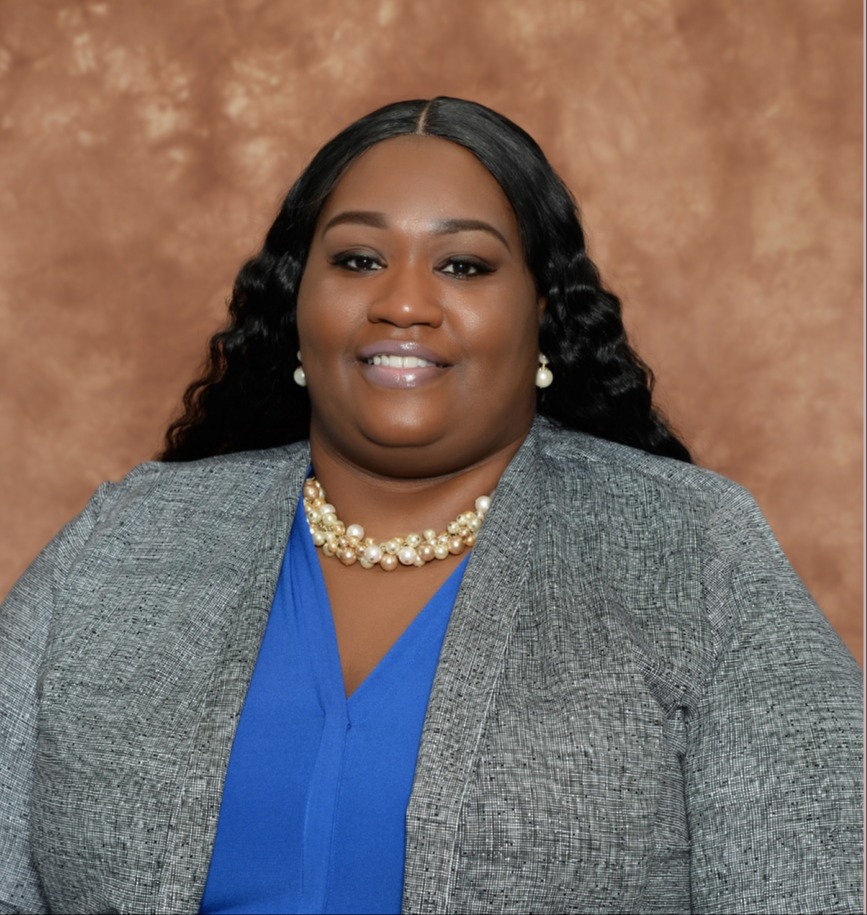A smiling woman is wearing a suit jacket.