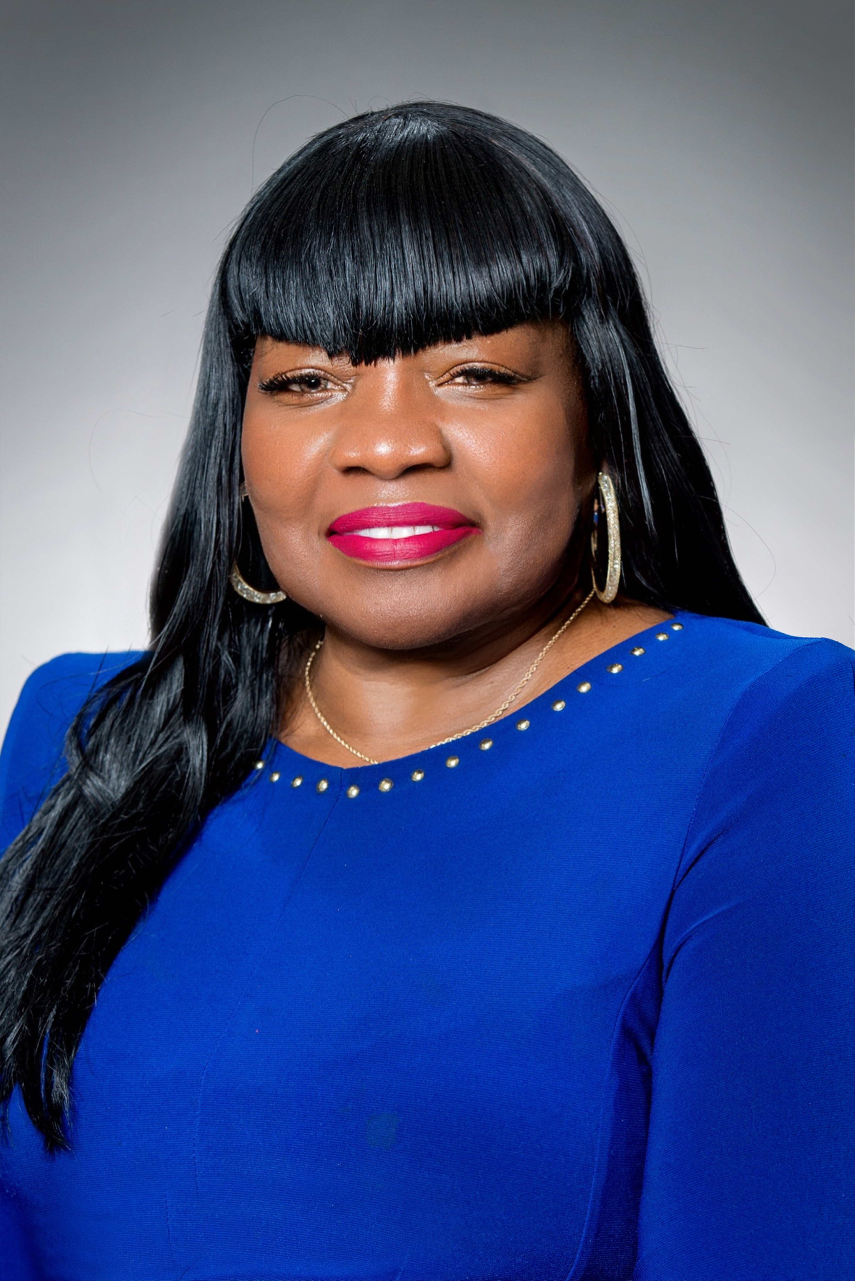A woman in a blue dress is holding flowers.