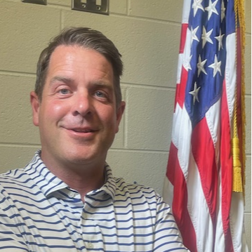 Image of man standing by american flag