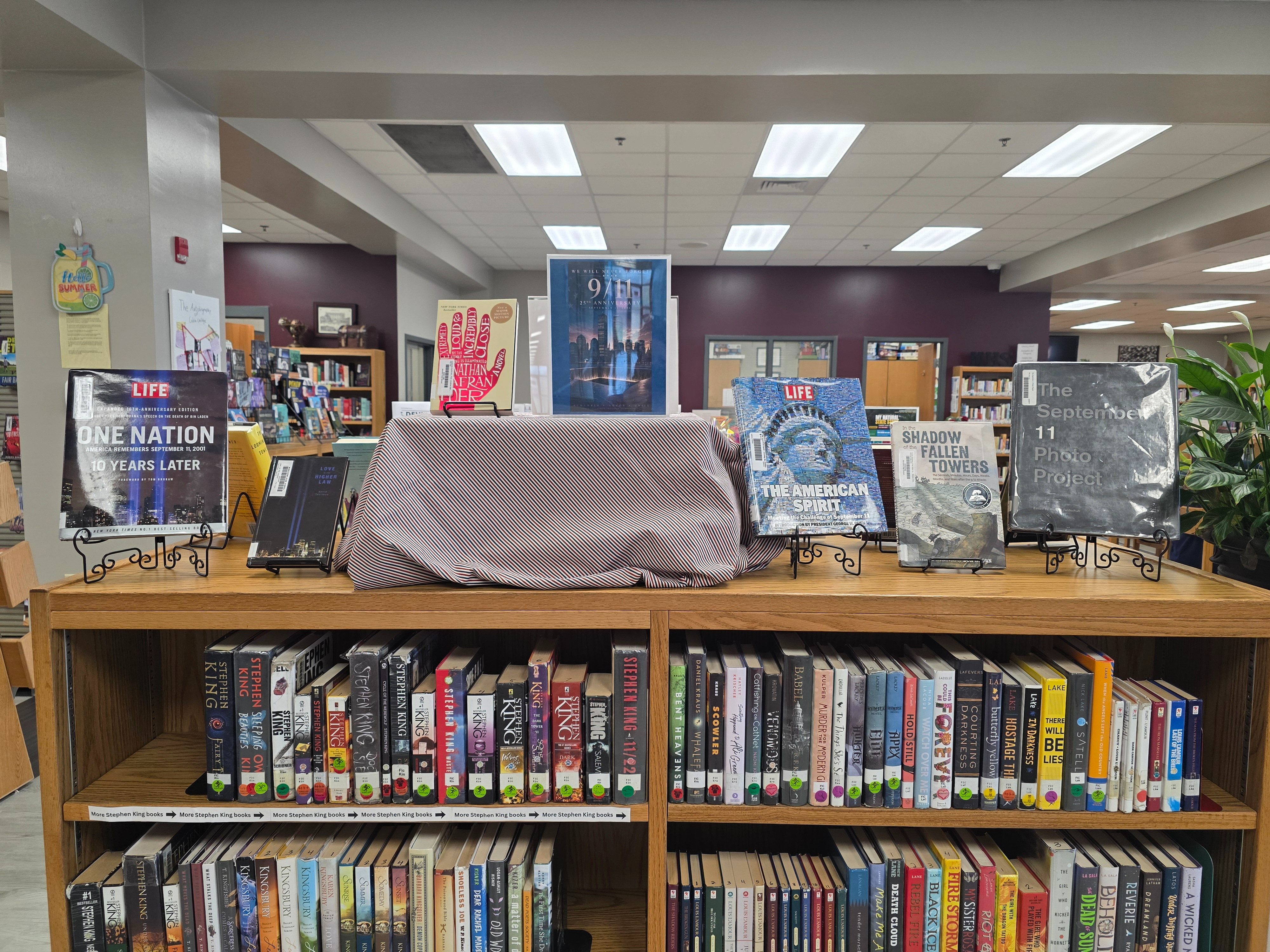 display of books about 9/11 sitting on top of bookshelf filled with books