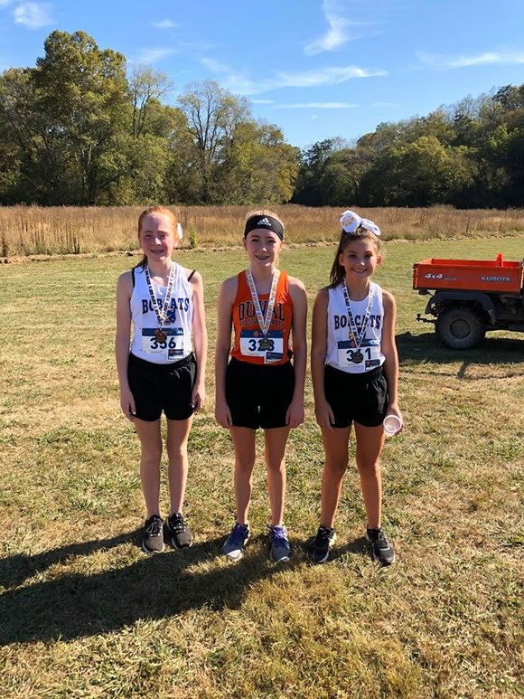 Three Cross Country students with medals