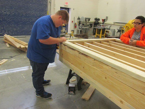Student assembling lumber pieces