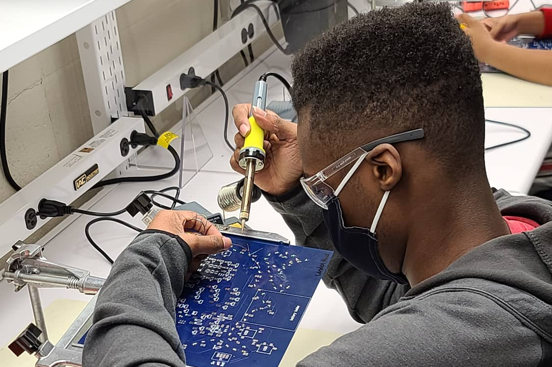 Student works on piece of computer equipment