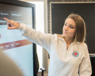 young women points at smart board