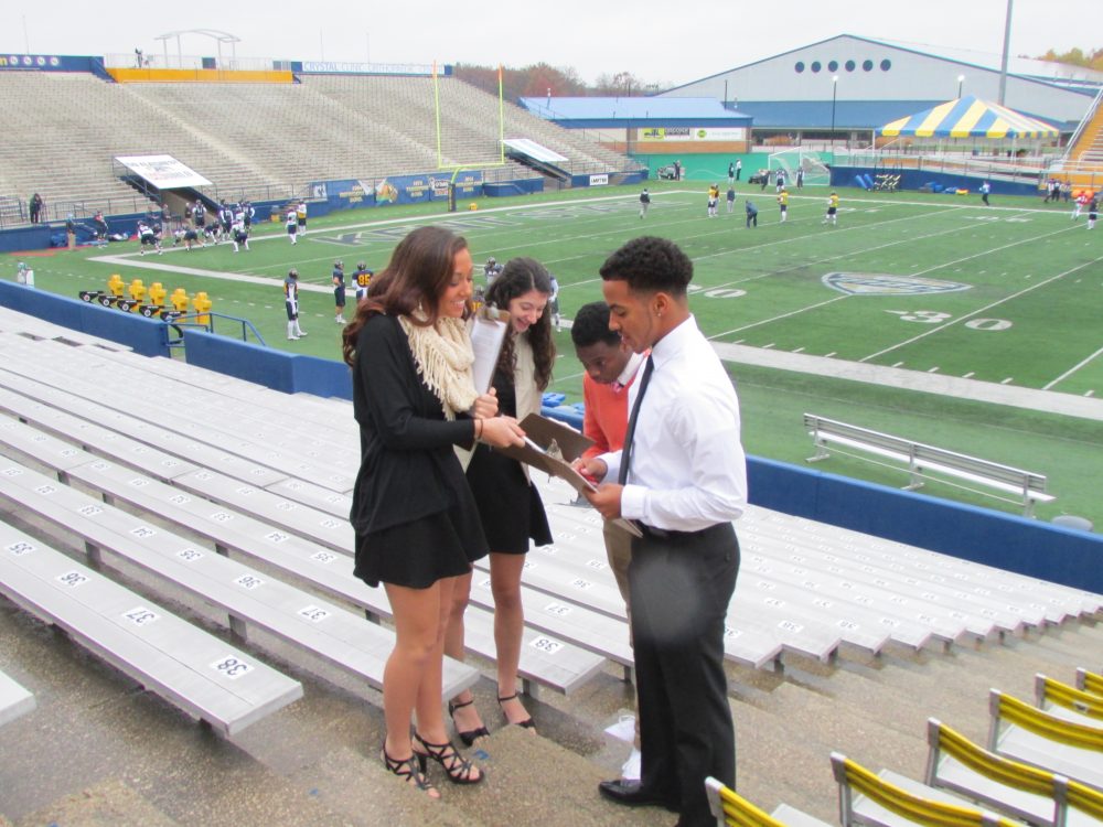 Students doing business on the bleacher steps