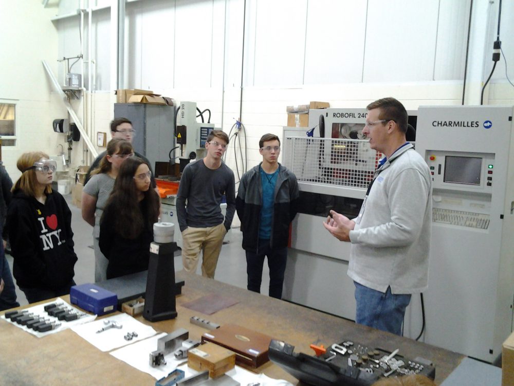 Students at Delta Systems listening to a tour guide