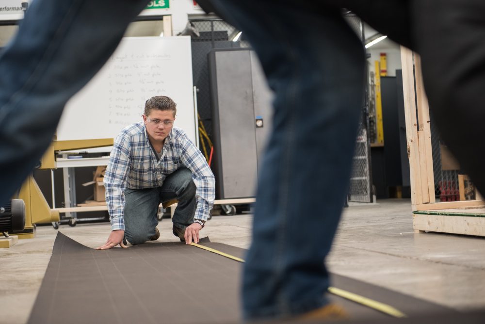 Construction students rolling out materials