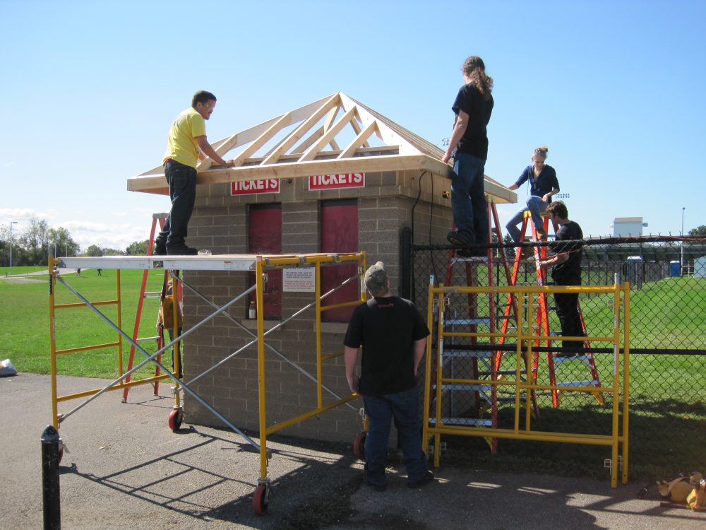 Construction students working on a roof for a ticket kiosk