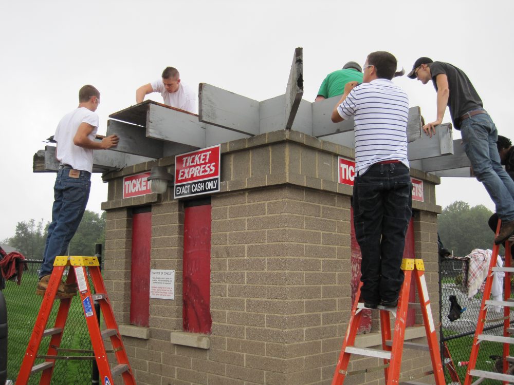 Construction students working on a roof for a ticket kiosk