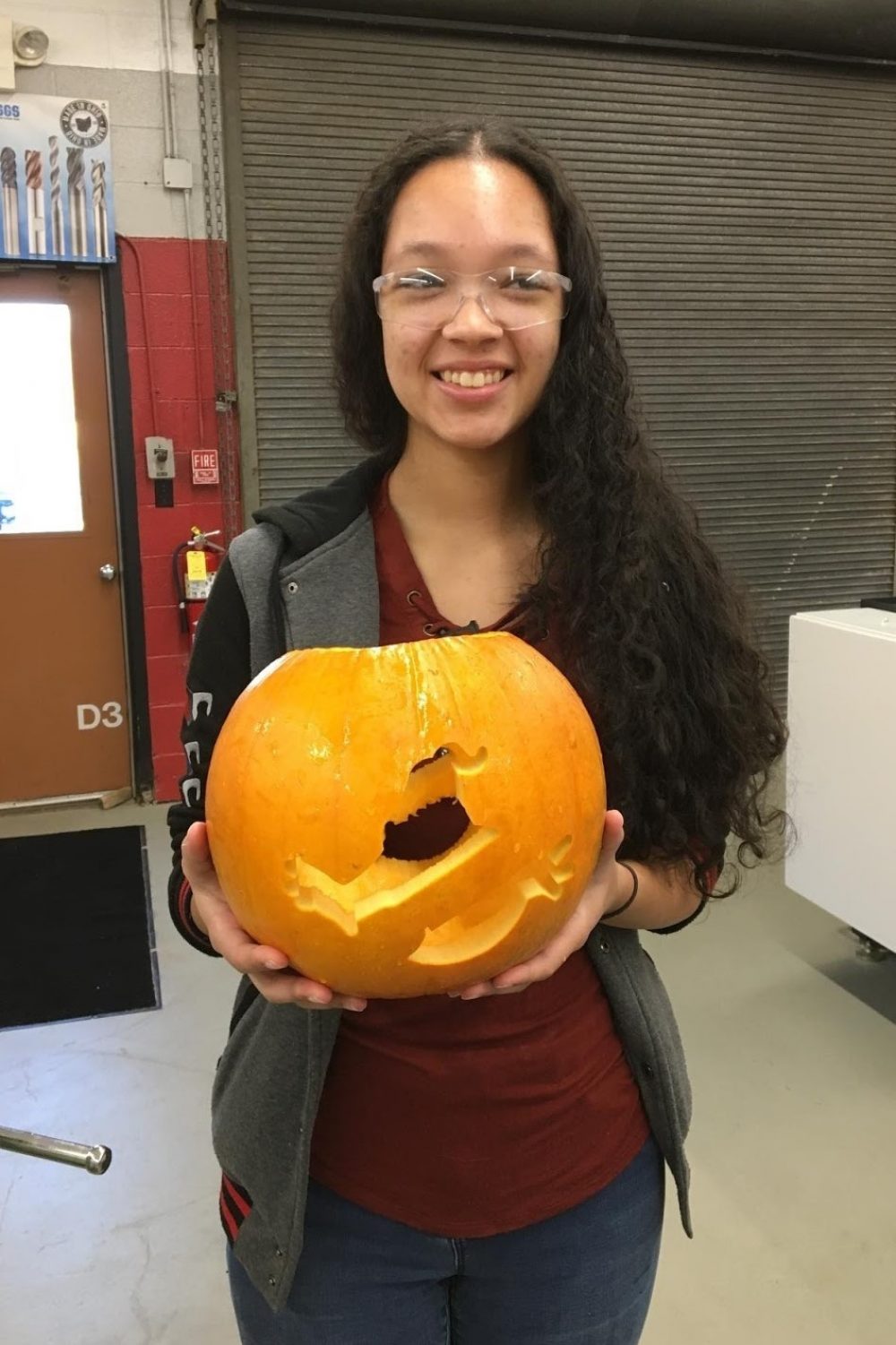 A student holding a pumpkin with the Ghostbusters logo