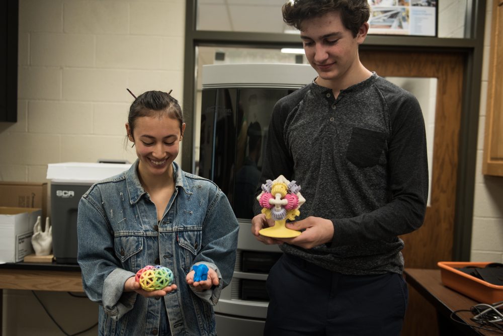 2 Students holding 3D printed projects