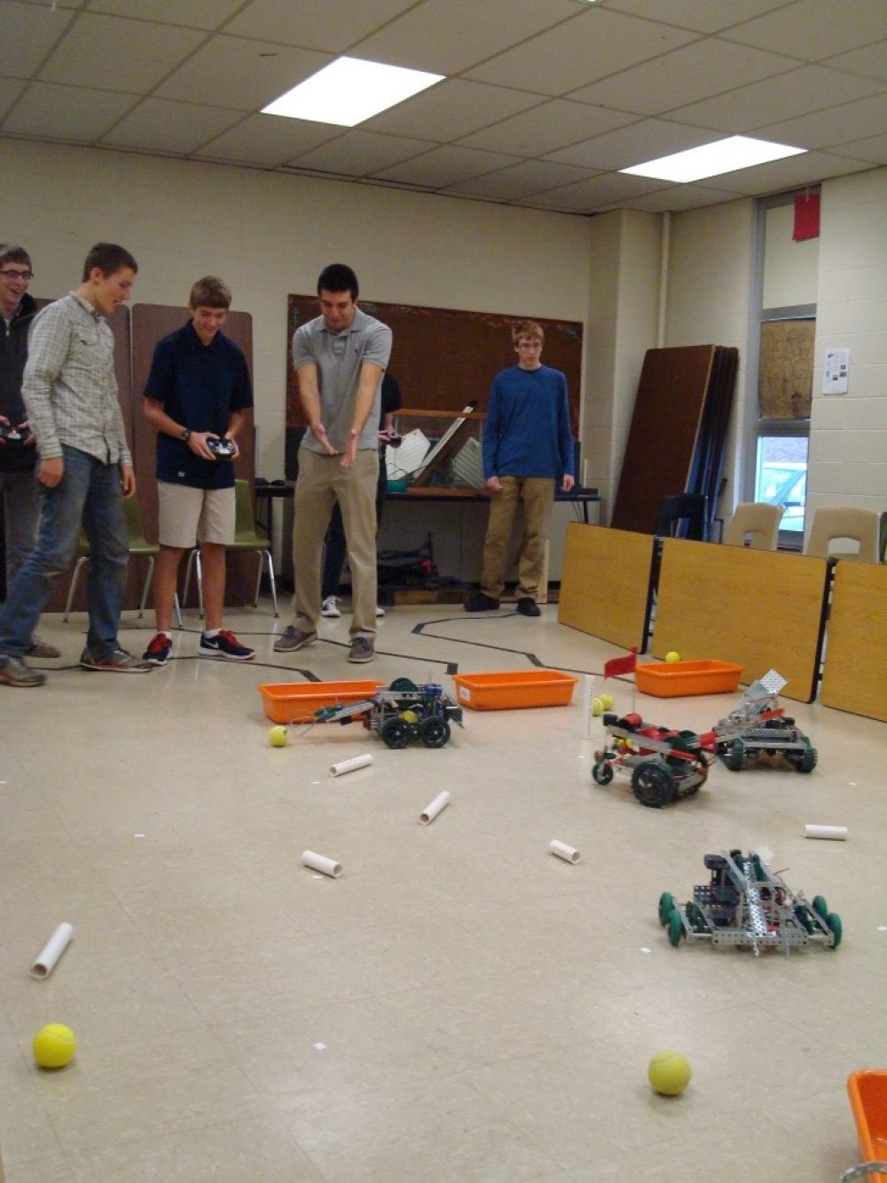 Several students controlling small robots