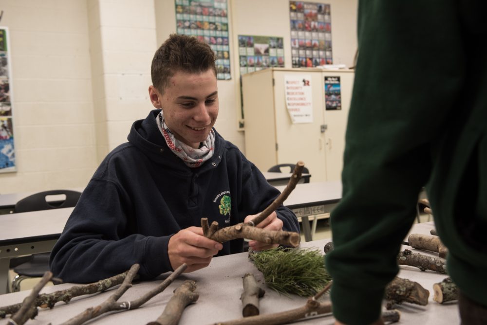 A student evaluating sticks in the classroom