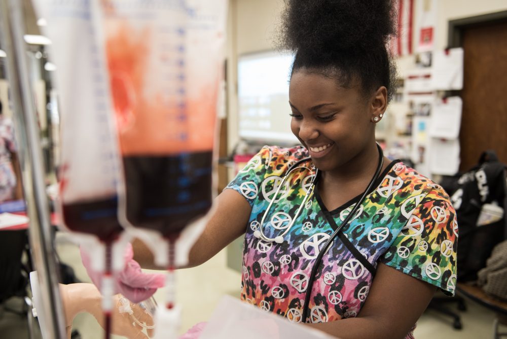 Student practicing giving medication through an IV