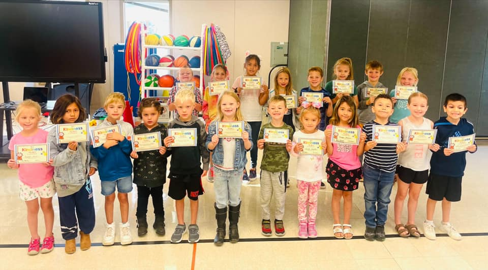 students take group picture with their Kindness Award certificates