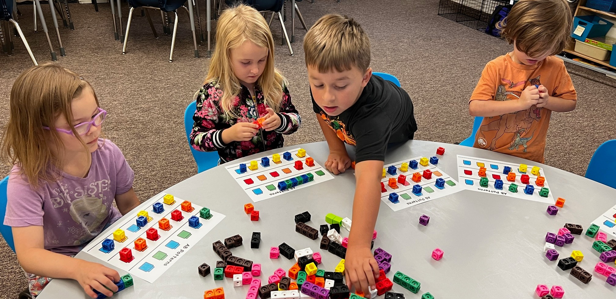 young students play with blocks at a table