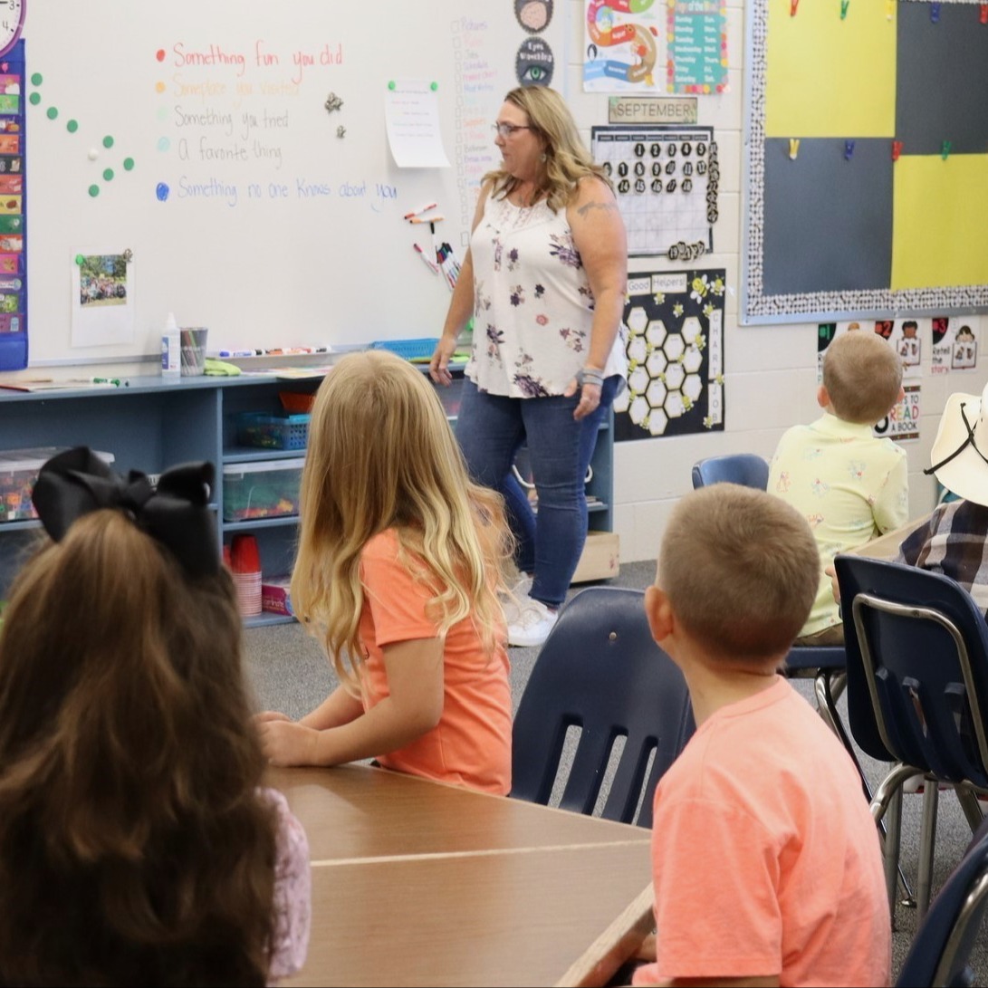 EV Classroom teacher at whiteboard with students at desks
