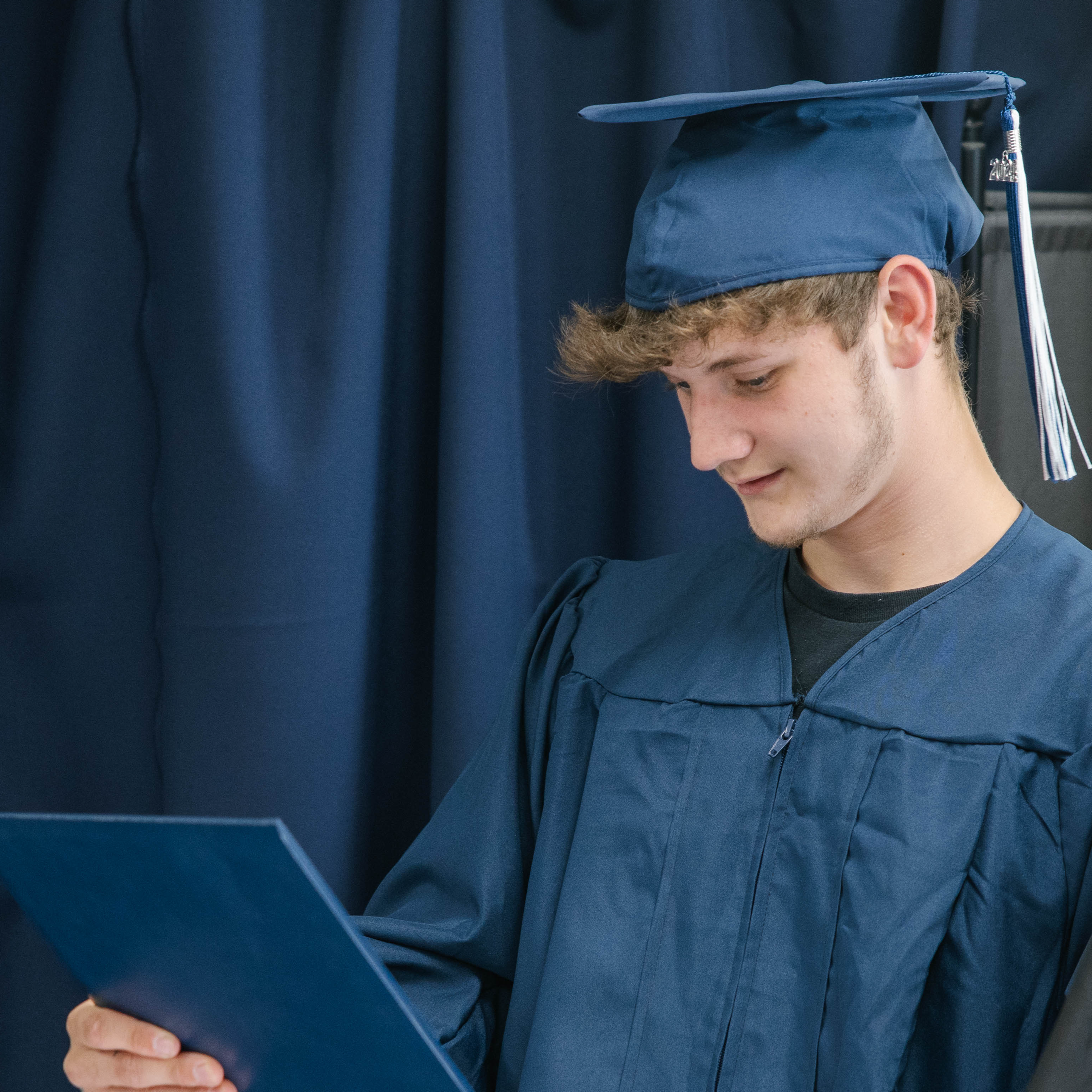 Graduate looking at diploma