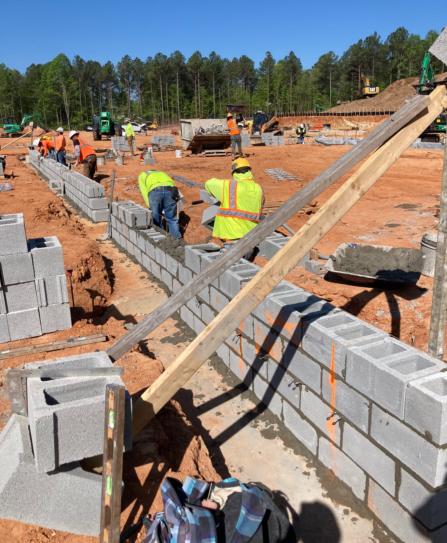 Construction workers building concrete block wall for gym