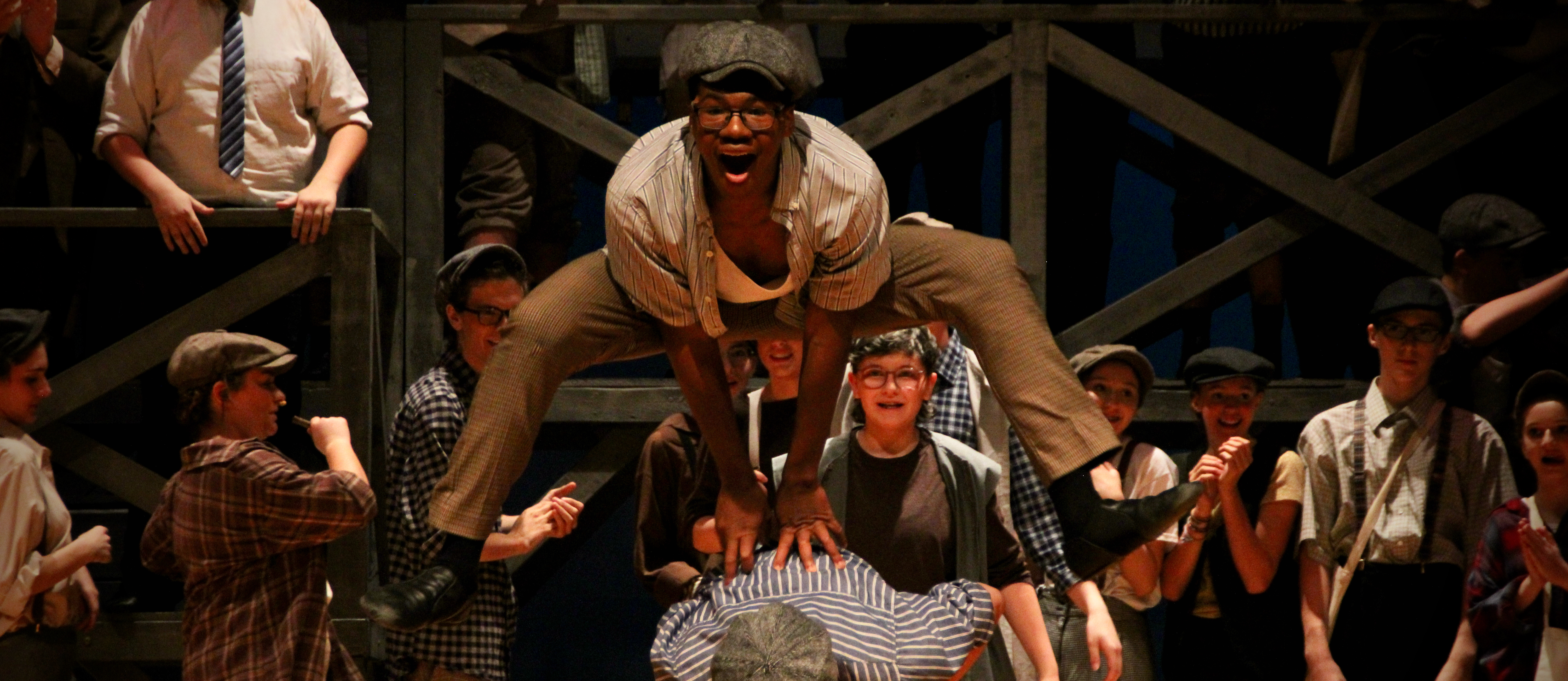 Student jumping over another student in the GHS performance of Newsies