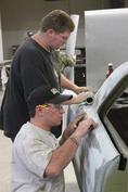 Students working on fixing a car