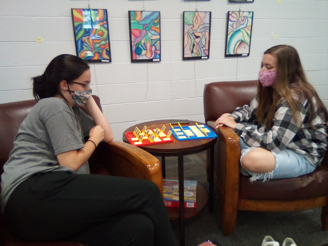 Students enjoying the library, reading books or playing board games