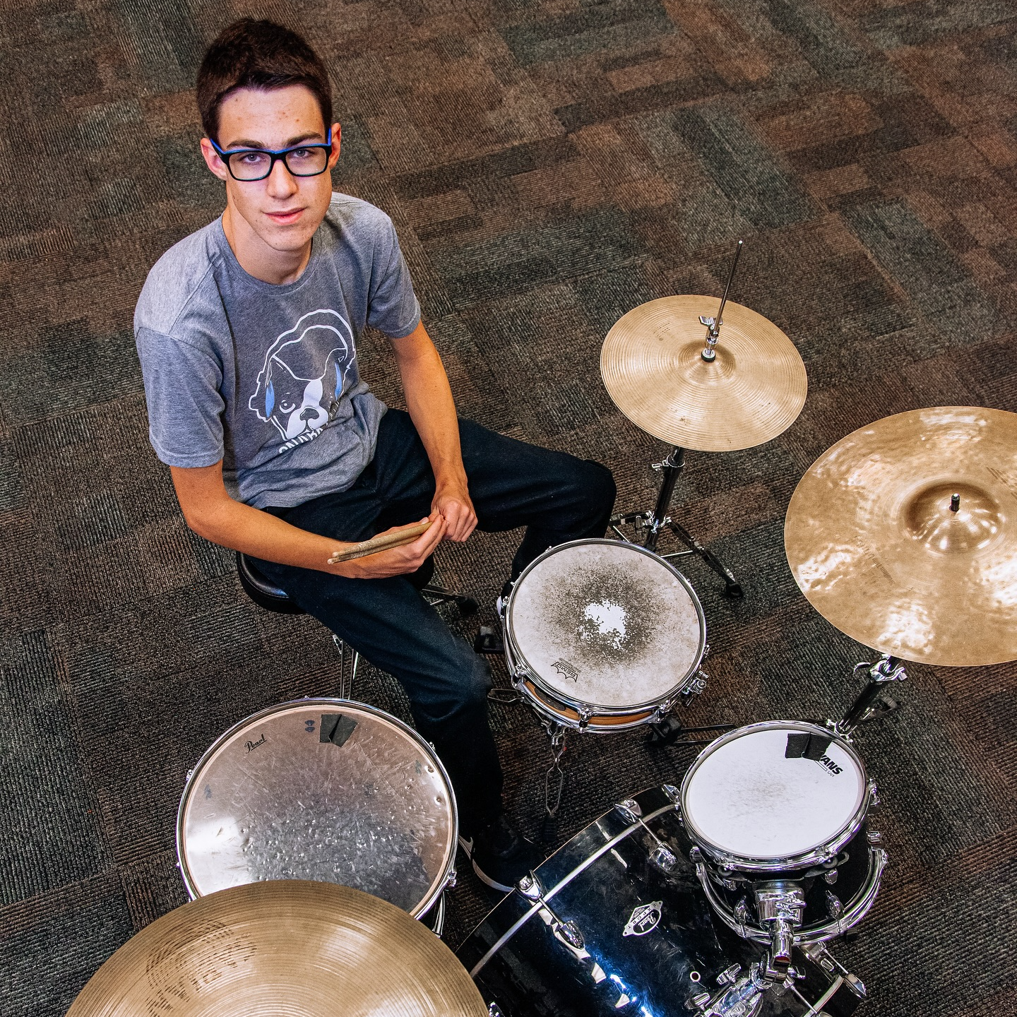 Student sitting by drums